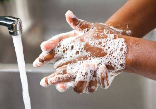 mains pleines de mousse avec savon noir africain