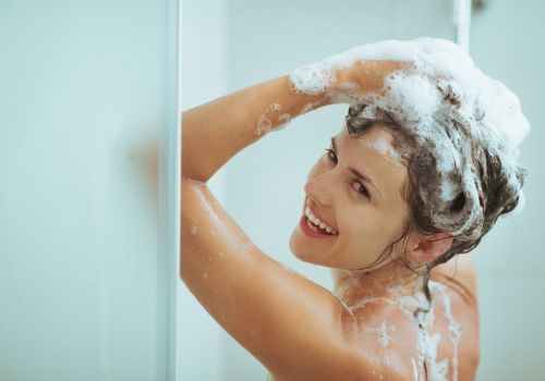 femme dans la douche utilisant shampoing lamazuna
