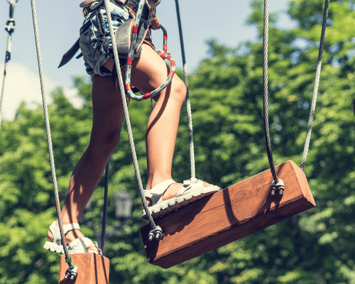 enfant en train de faire de l'accrobranche